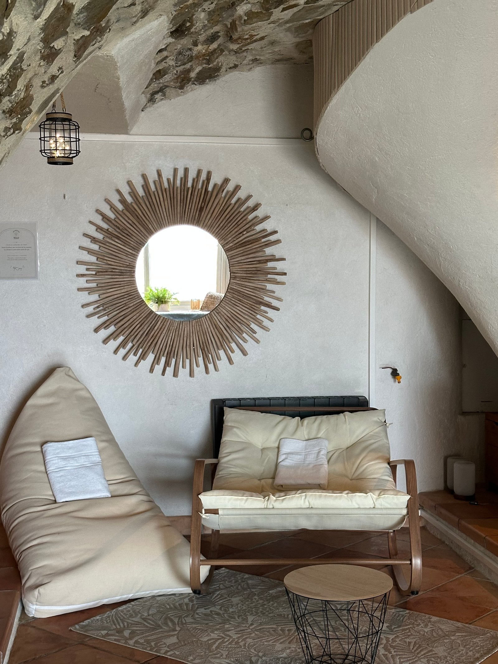 Coin repos avec pouf, fauteuil et miroir soleil
